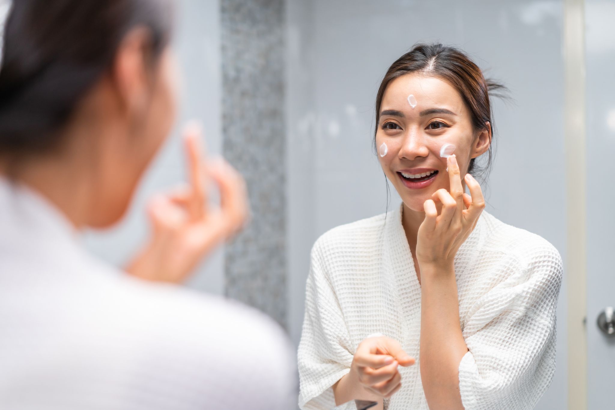 顔にクリームを塗る女性